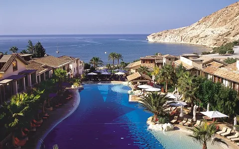 Resort swimming pool and gardens overlooking the sea and cliffs at Pissouri, Cyprus.