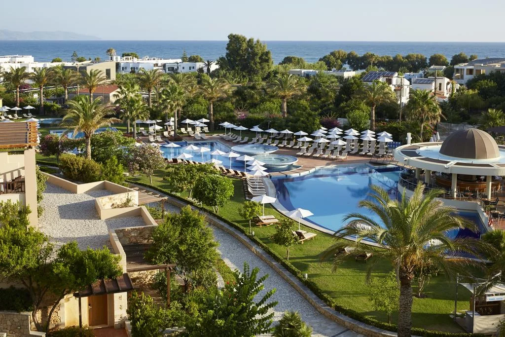 Swimming pools, palms and gardens at Minoa Palace Resort with the sea beyond.